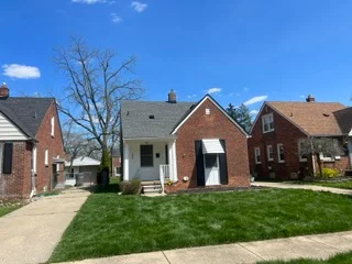 Brick residential home with newly installed asphalt shingle roof and attached garage