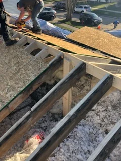 Metal roof framing beams and wooden trusses during installation with flashing details