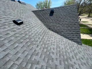 Newly installed gray architectural asphalt shingle roof with multiple valleys and roof vents