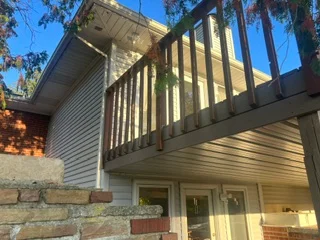 Pressure-treated deck with vertical spindle railing and stone foundation base
