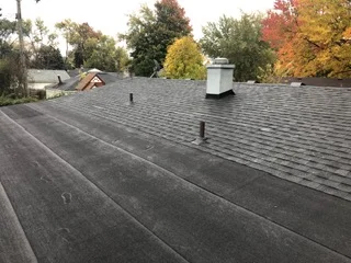 Charcoal gray asphalt shingle roof with flashing and roof vents installed
