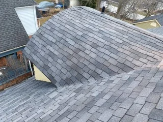 Charcoal gray architectural shingles installed on residential roof with proper staggered pattern and valley flashing