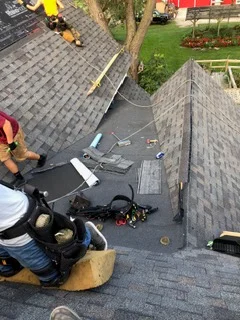 Asphalt shingle roof installation with gray architectural shingles and proper overlapping courses