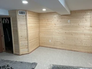 Basement interior with pine-framed walls, drywall, recessed lighting, and concrete floor