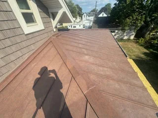 Brown architectural asphalt shingles installed on residential roof with proper alignment and coverage
