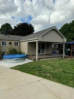 New asphalt shingle roof and vinyl siding on residential home with concrete patio
