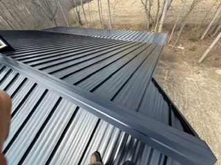Standing seam metal roof with dark gray panels and visible ridge detail