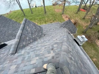 Aerial view of newly installed gray asphalt shingle roof with proper overlap and alignment