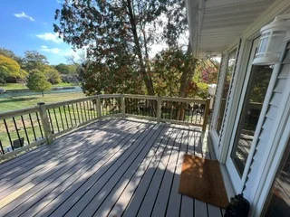 Composite deck with black railing, wood-grain decking boards, and metal balusters
