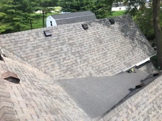 New asphalt shingle roof installation with gray composite shingles and roof vents