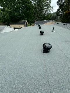 Gray flat roof membrane with installed vents and penetrations