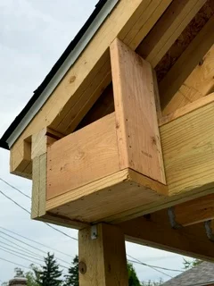 Wood soffit and fascia installation on residential overhang with pressure-treated lumber framing