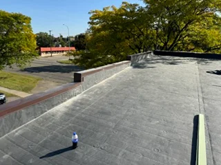 Commercial flat roof with gray membrane system and metal edge trim